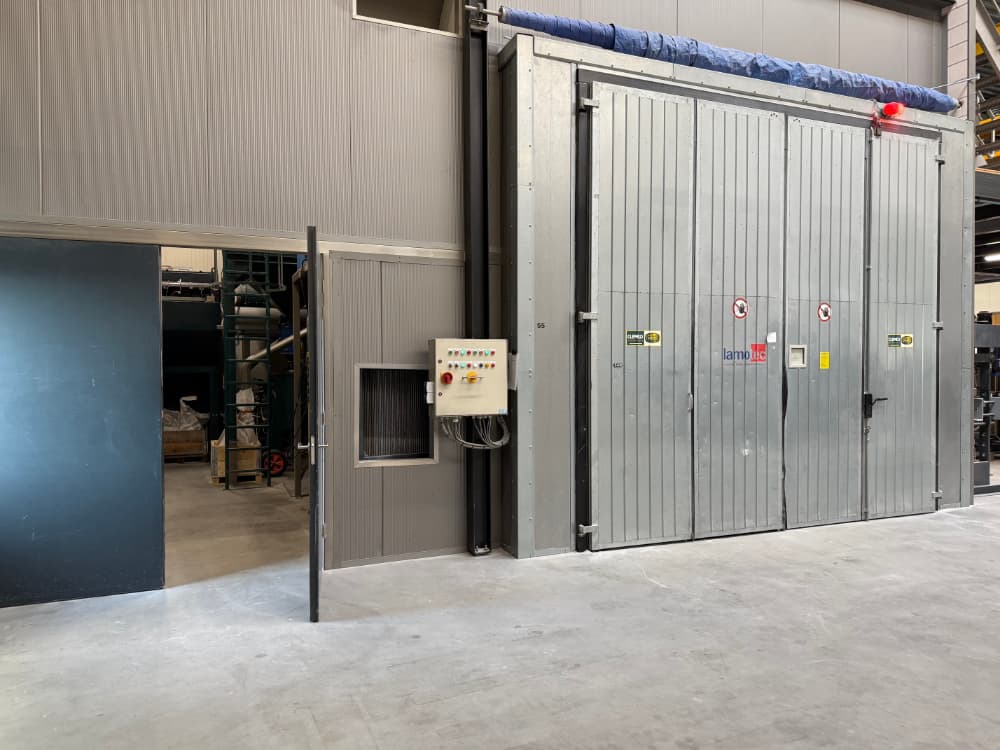 Buitenkant van de grote straalcabine van Lamotec met open deur van de machinekamer